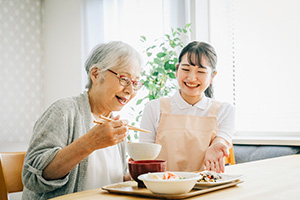 ご利用者様が食事を笑顔で見守る様子