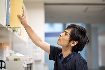 看護師Yさんが棚からファイルを取り出している様子