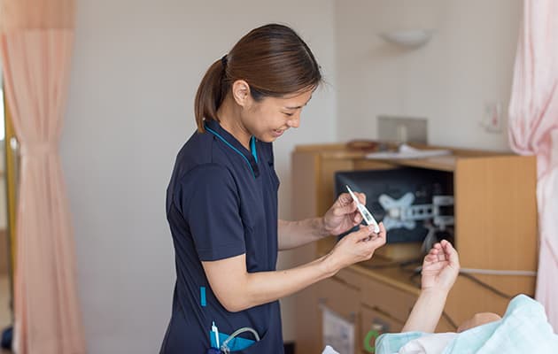 看護師Mさんが体温を測る様子